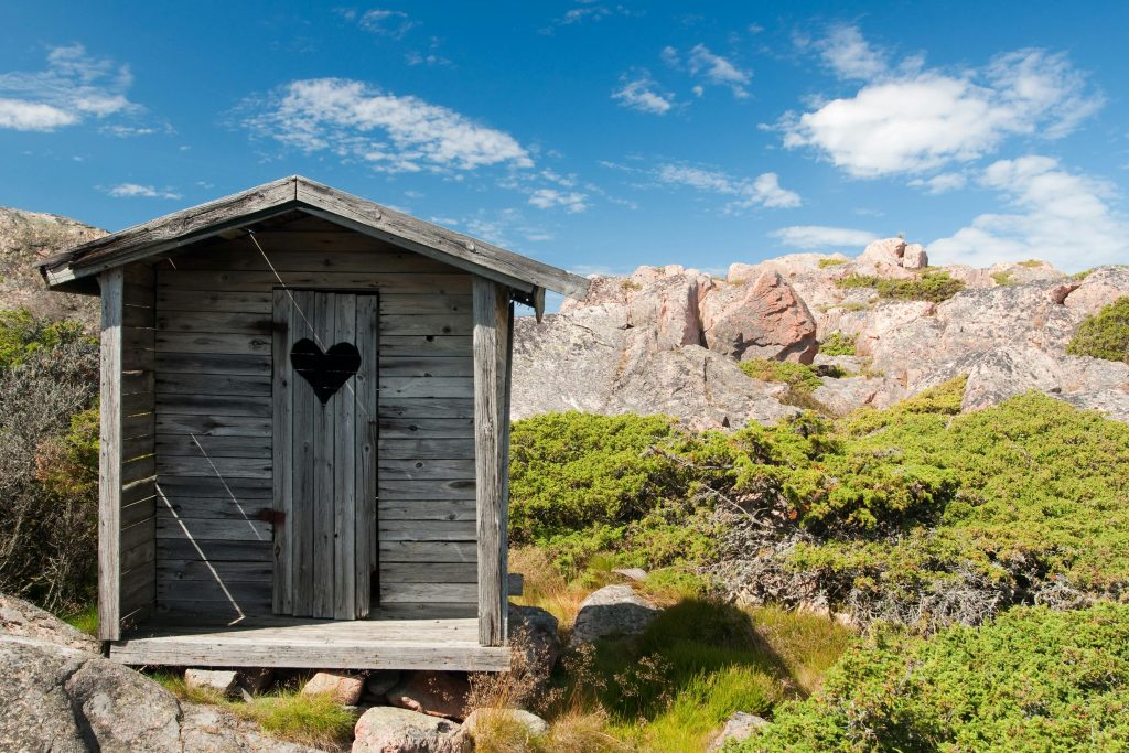 pexels-photo-277696-277696 Charming rustic wooden cabin with heart-shaped door in rocky countryside.